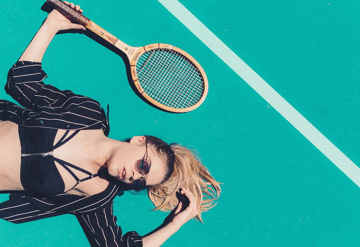 people woman lying on floor holding tennis racket racket