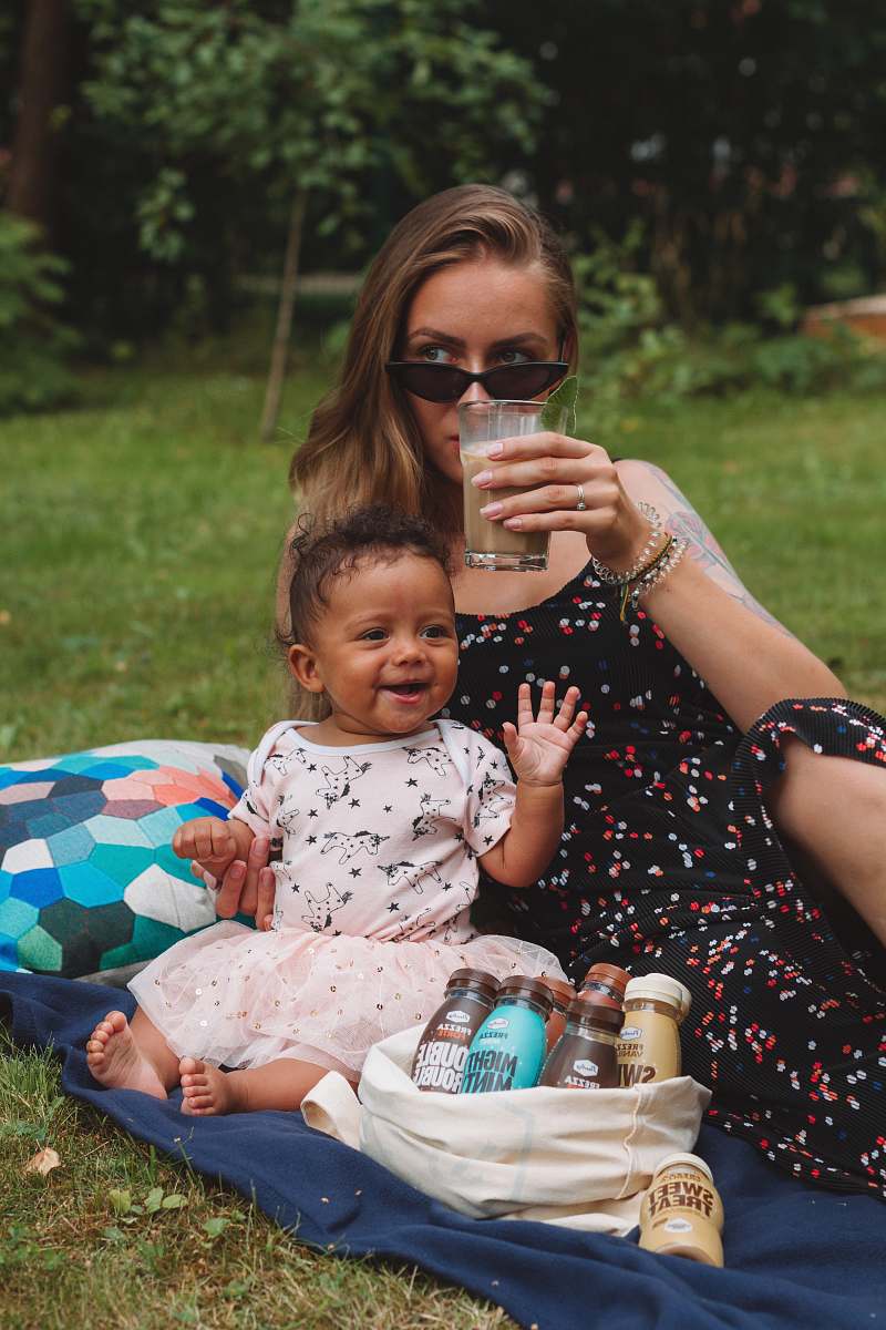 grass woman sitting beside baby on grass field plant