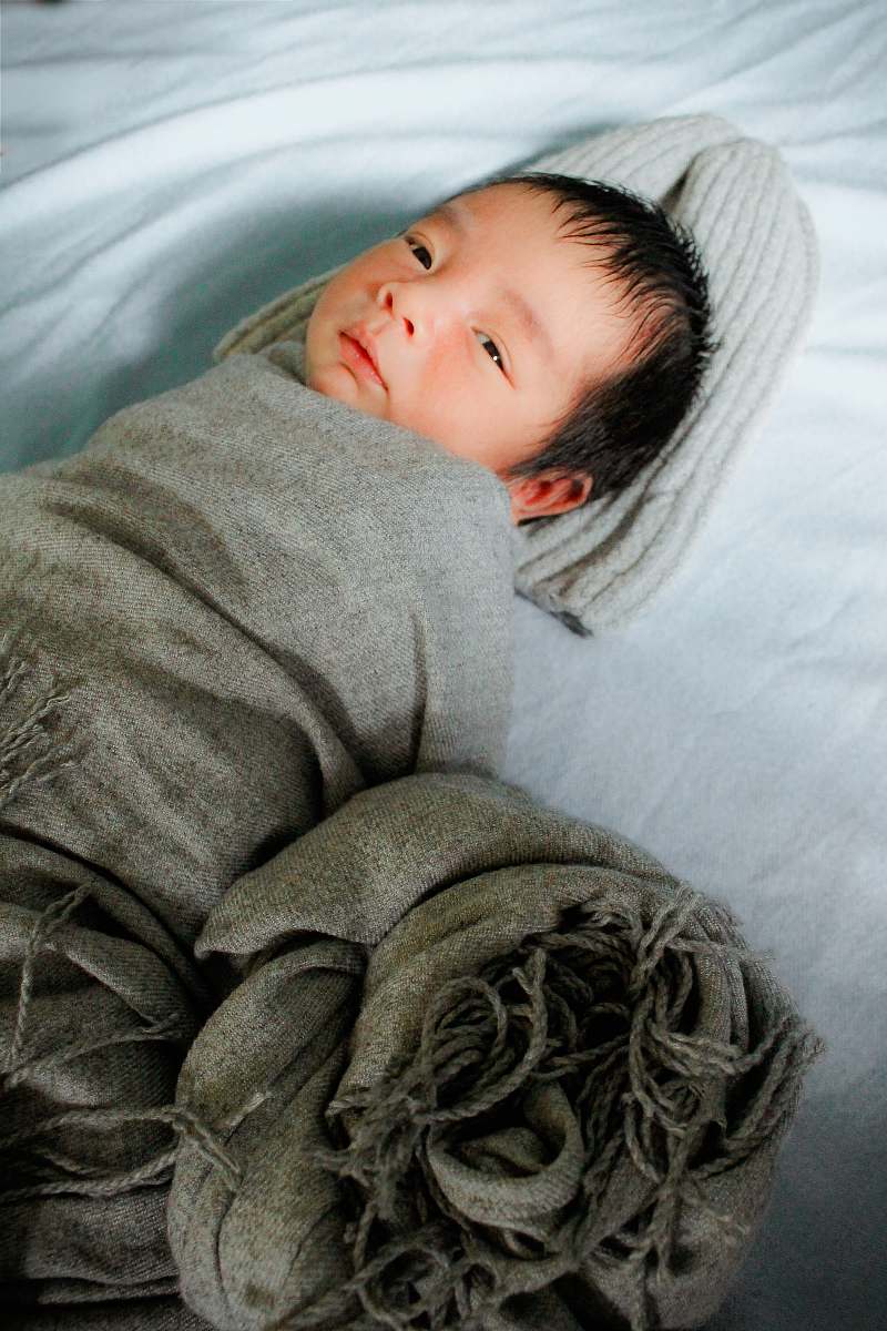 human baby in gtey blanket person