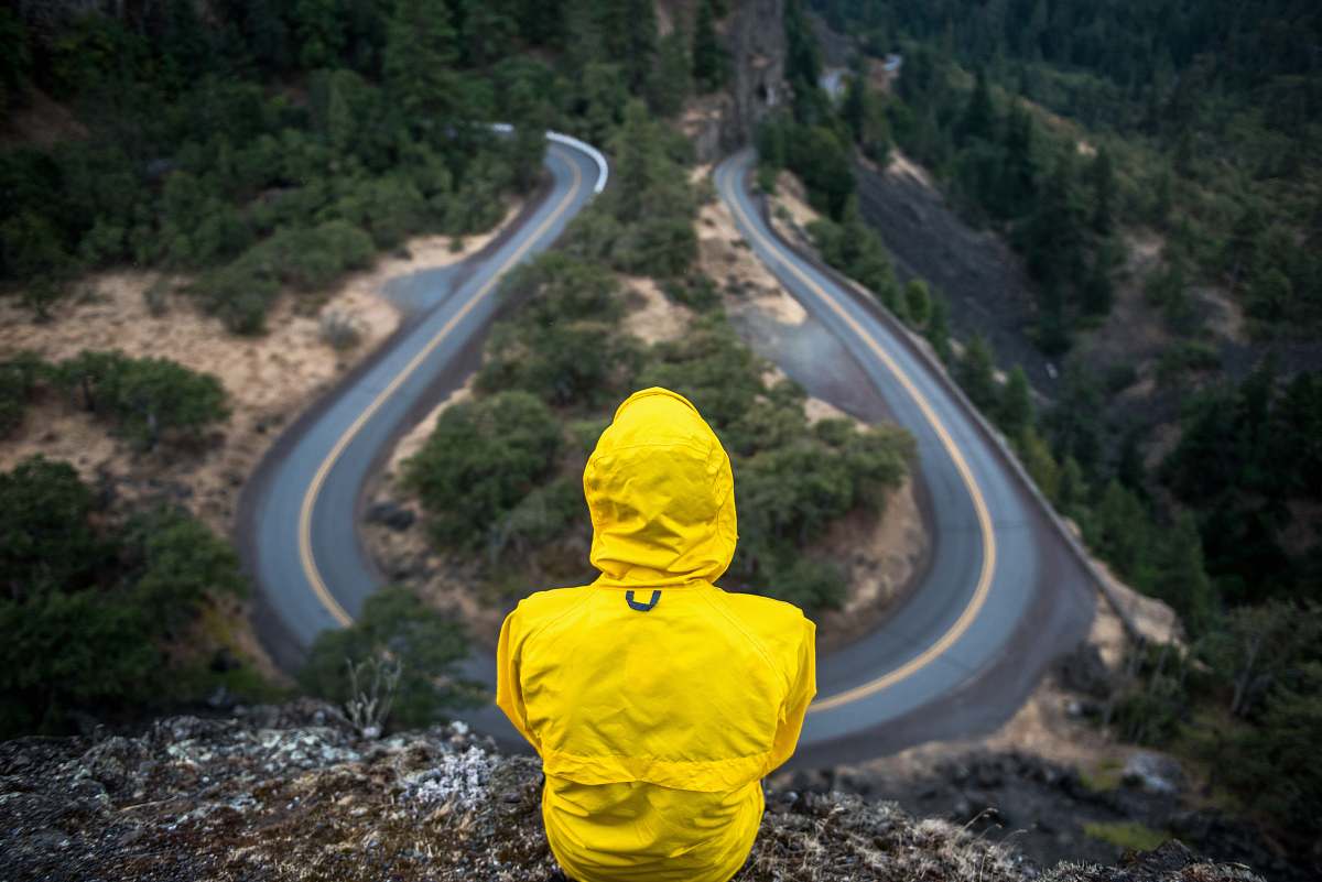 people person in yellow coat standing on top of hill yellow