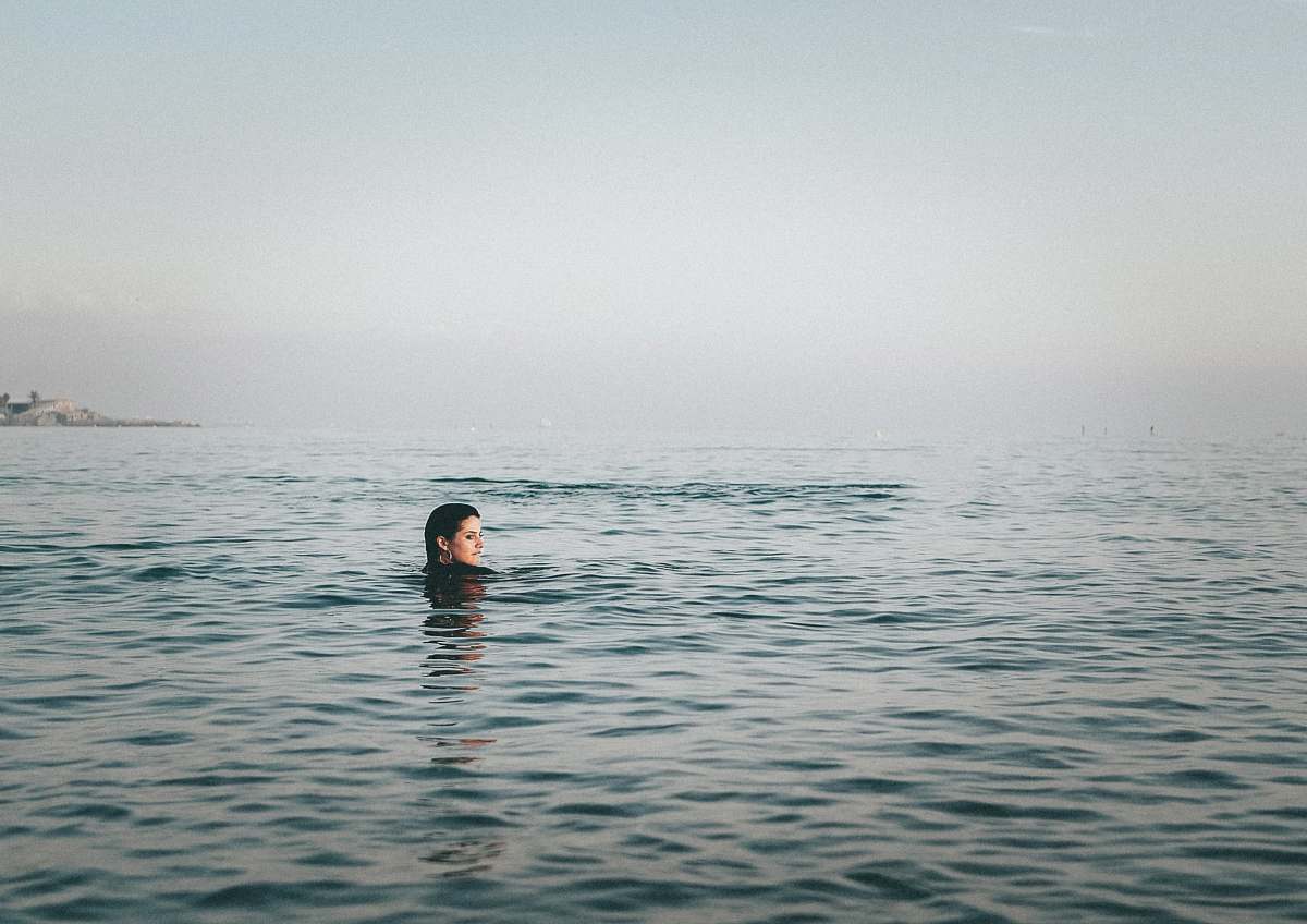 swimming person on body of water during daytime sport