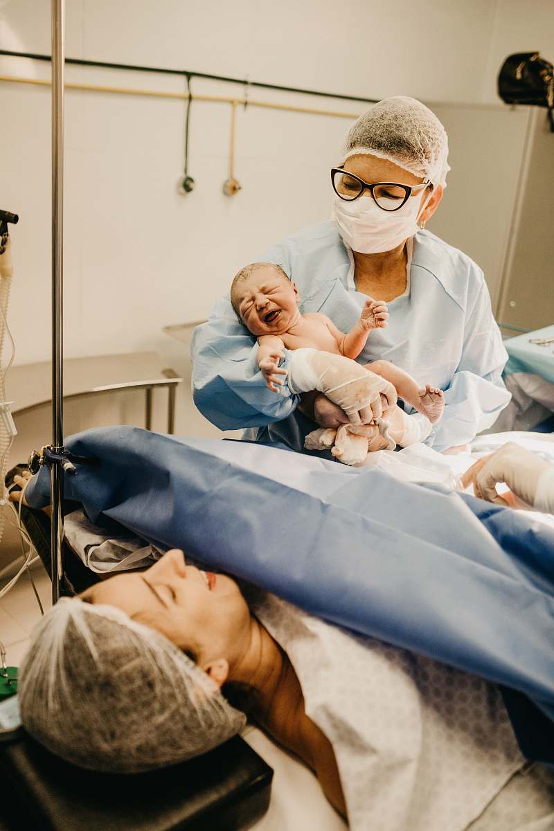 human shallow focus photo of person carrying topless baby clinic