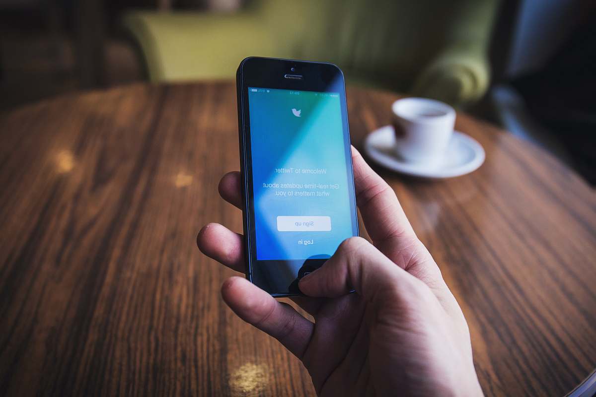 iphone person holding turned on space gray iPhone 5c near table cell phone