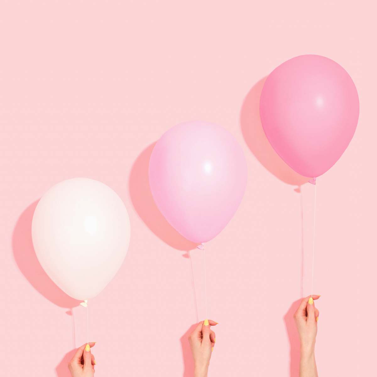 balloon person holding pink and white balloon ball