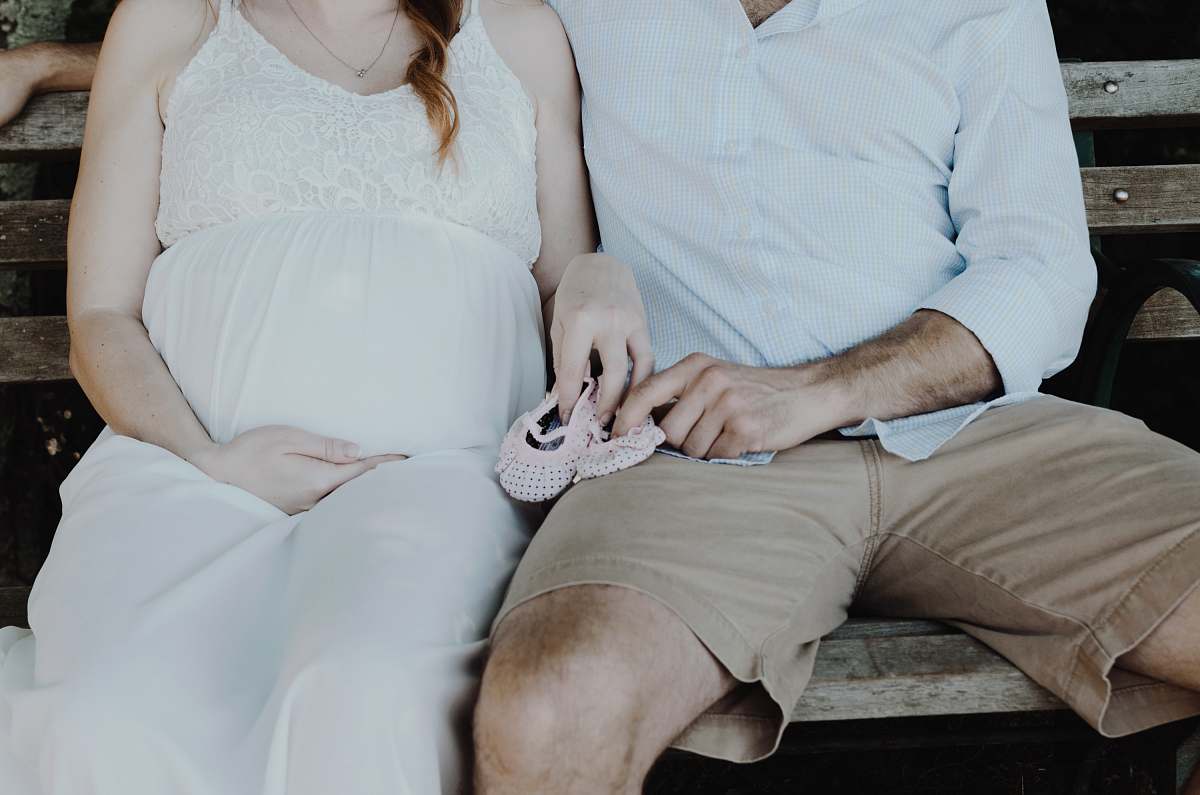 expecting close-up photo of man and woman sitting on bench pregnant