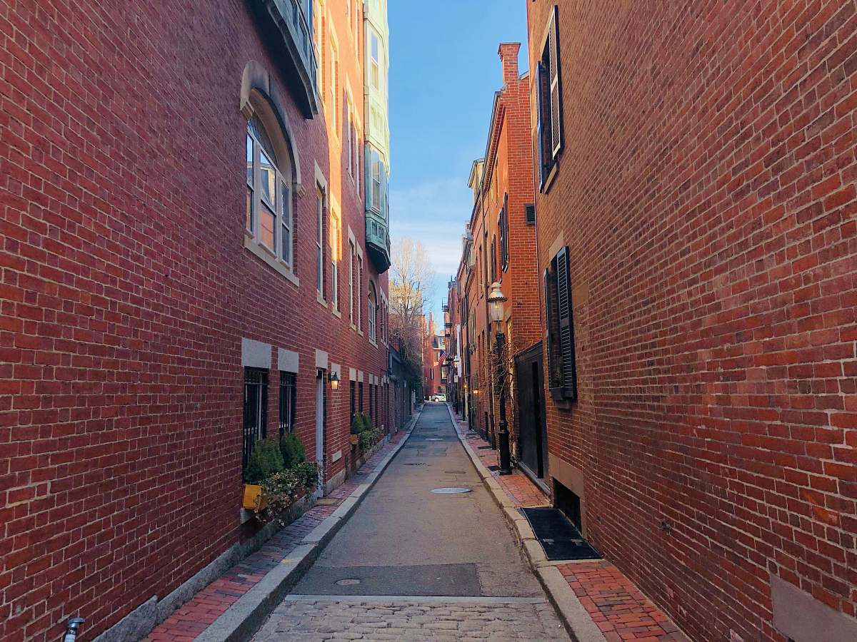 city empty pavement in between brick building during daytime street