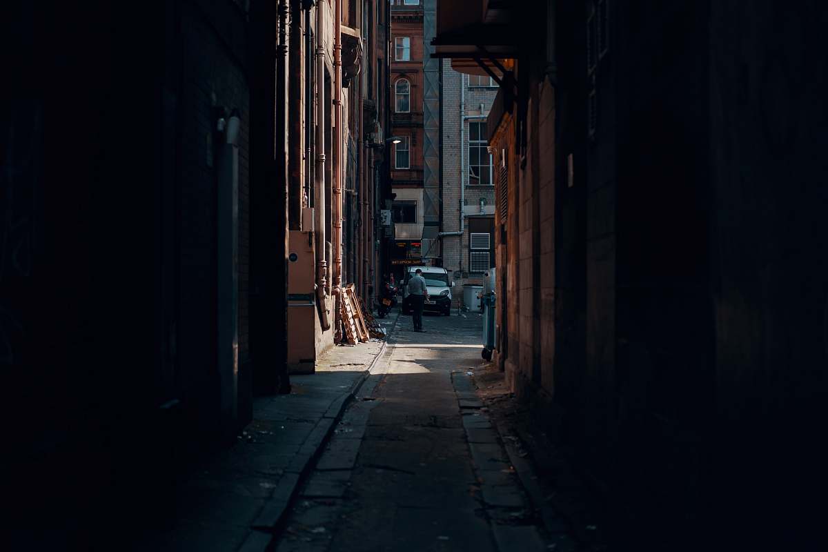city person walking beside building near vehicle urban