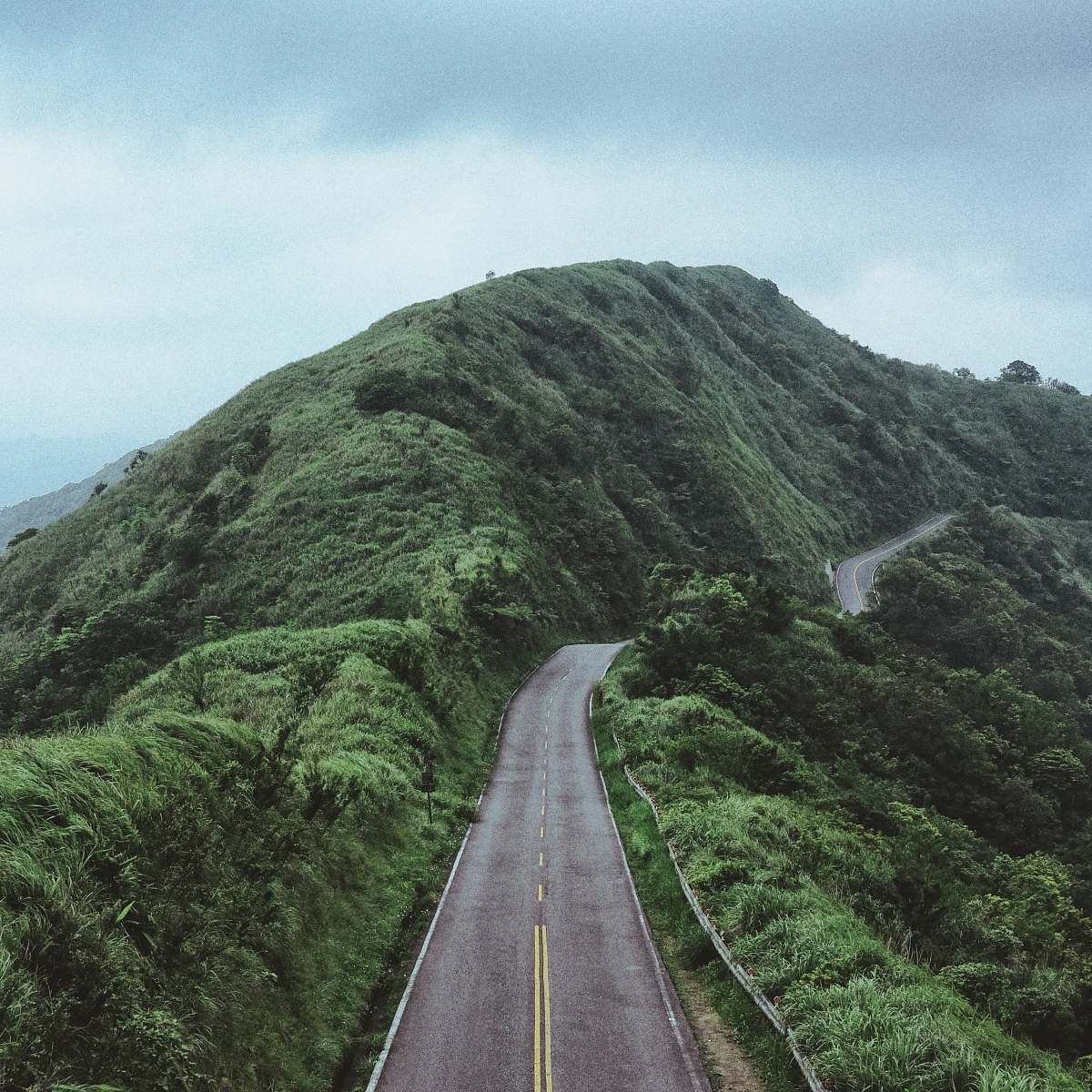 mountain photo of road between mountain hill