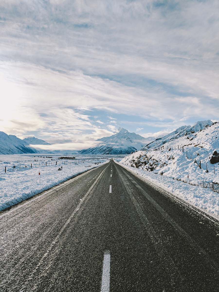 mountain road near mountain covered with snow snow
