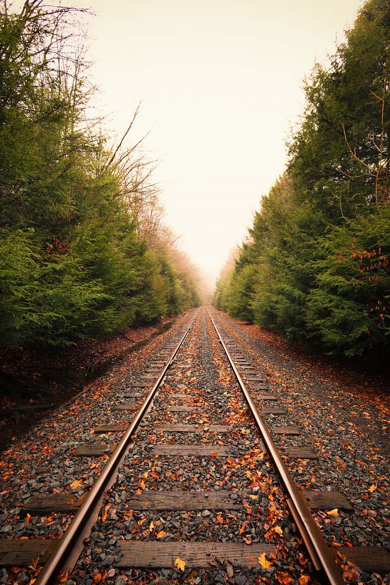 gravel train rail during daytime dirt road