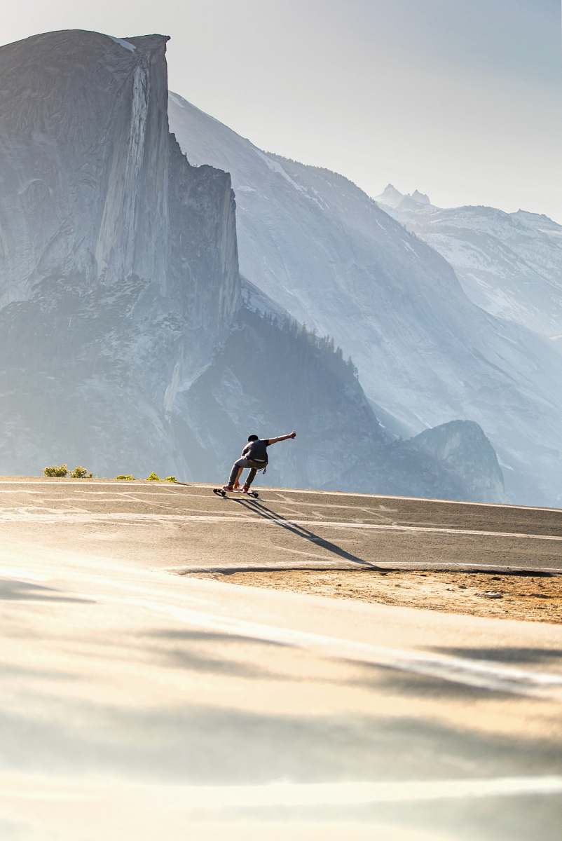 mountain man riding longboard cliff