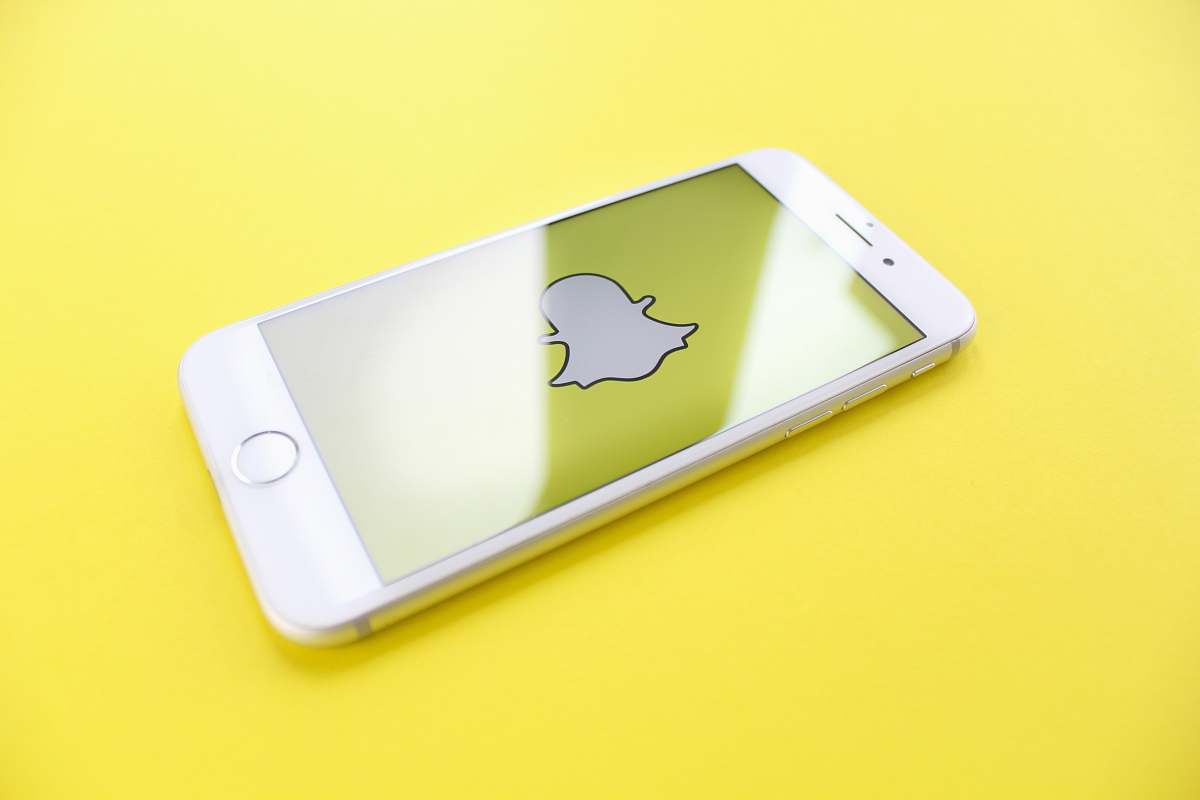 snapchat silver iPhone 6 on top of yellow wooden surface app