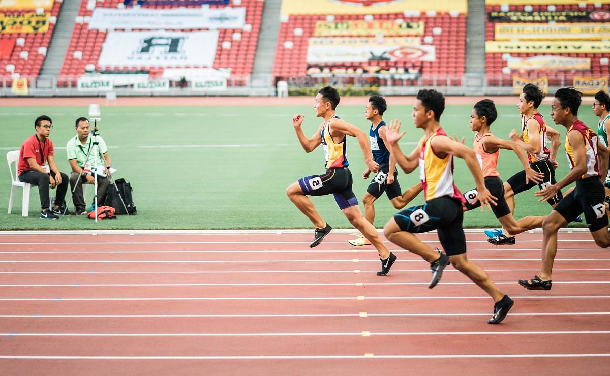 sports group of men running in track field people