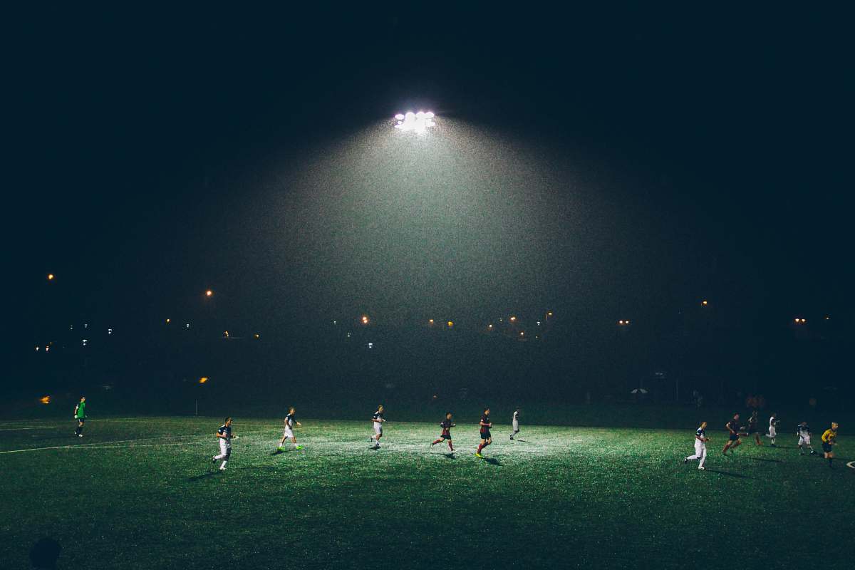 football group of people playing soccer on soccer field soccer