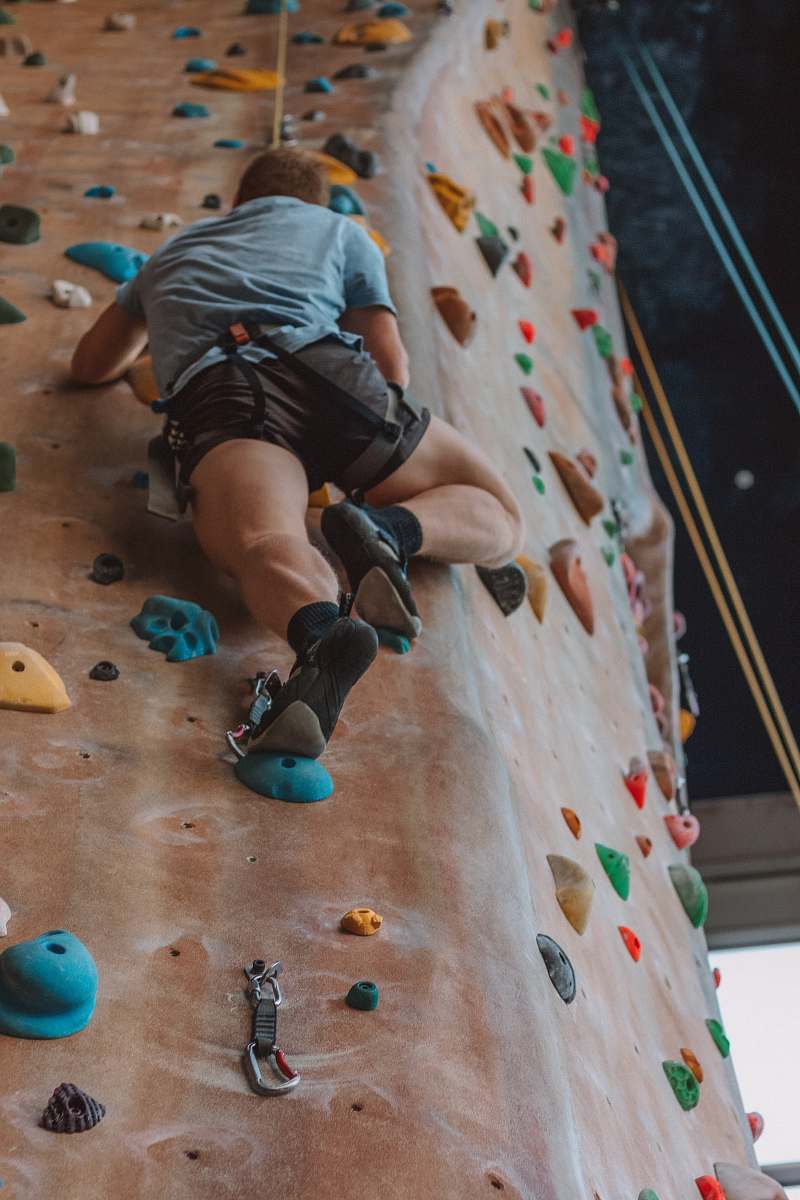 outdoors man rock climbing inside climbing area at daytime rock climbing