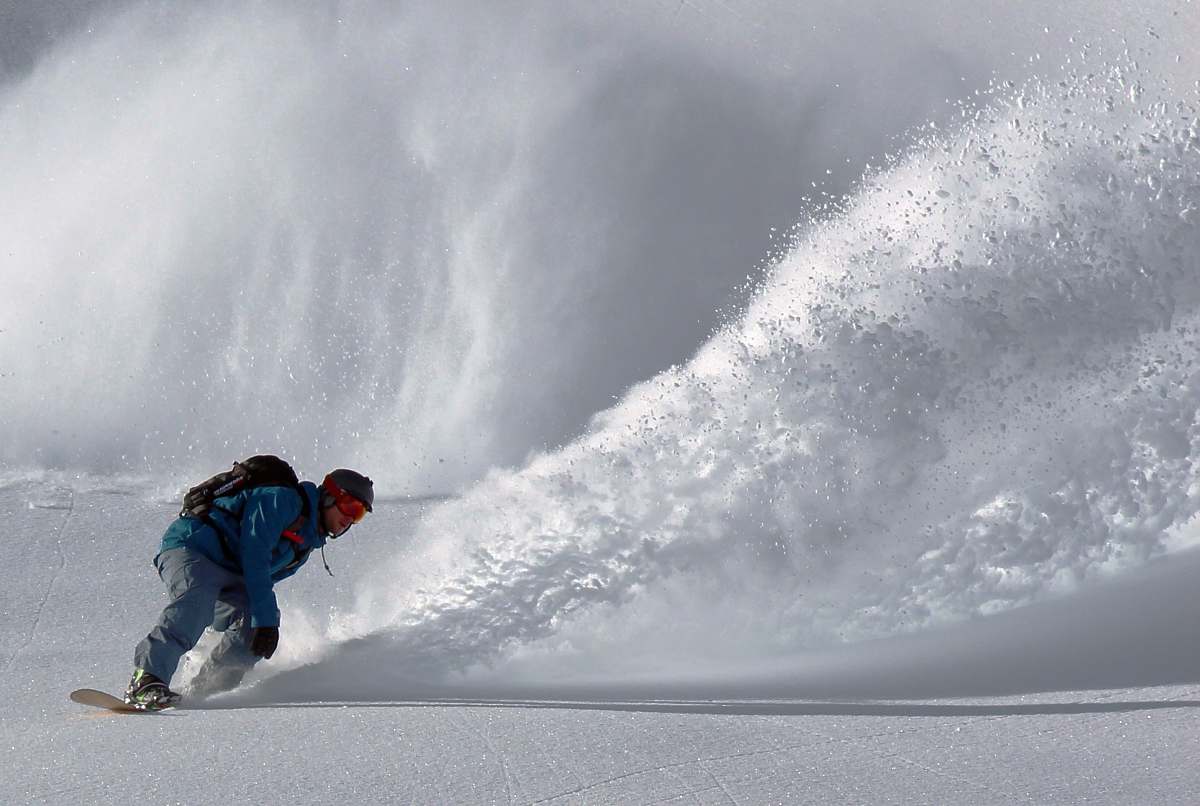 snowboarding person gliding in snow during day time snow
