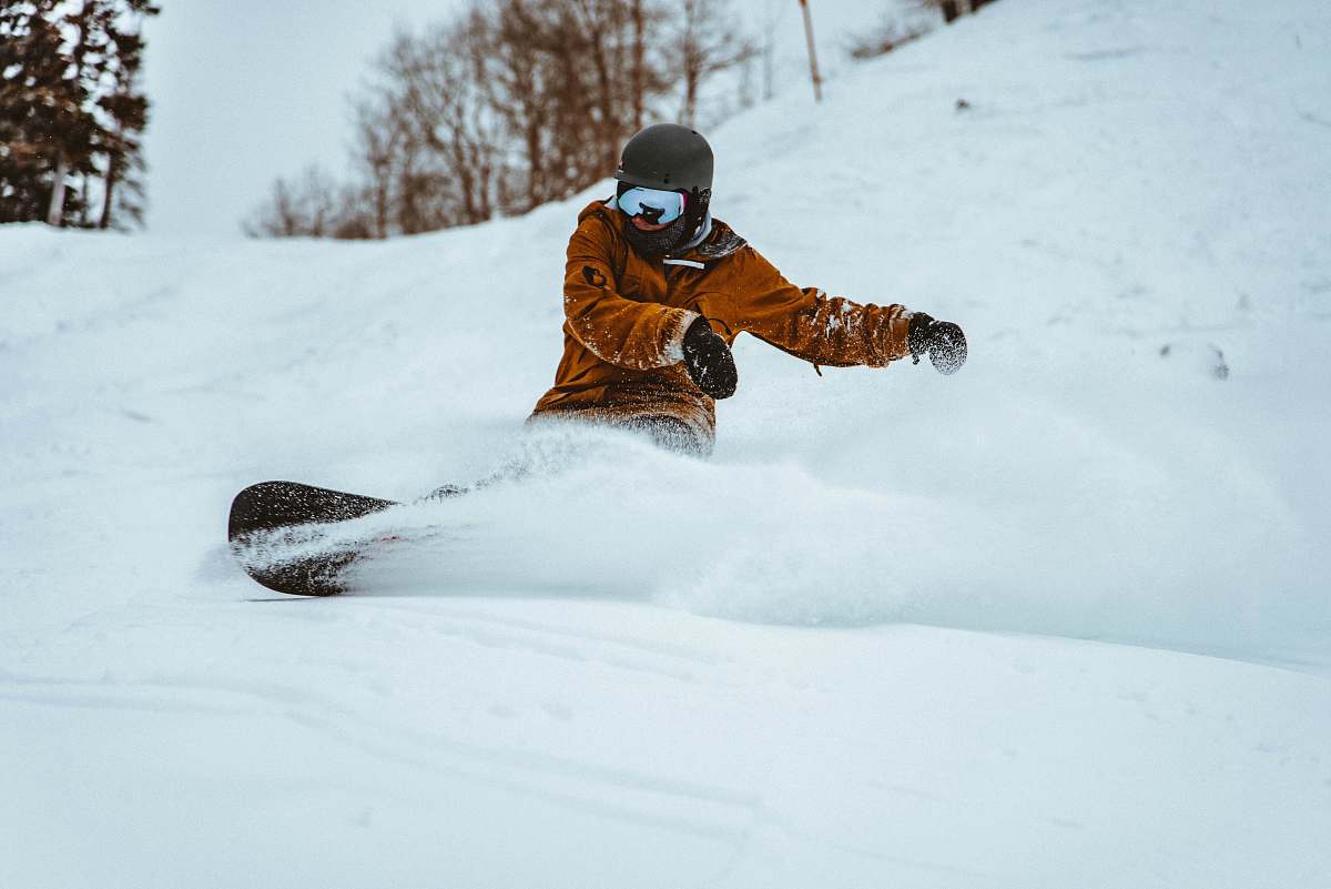 snowboarding photography of person playing snowboarding during daytime outdoors