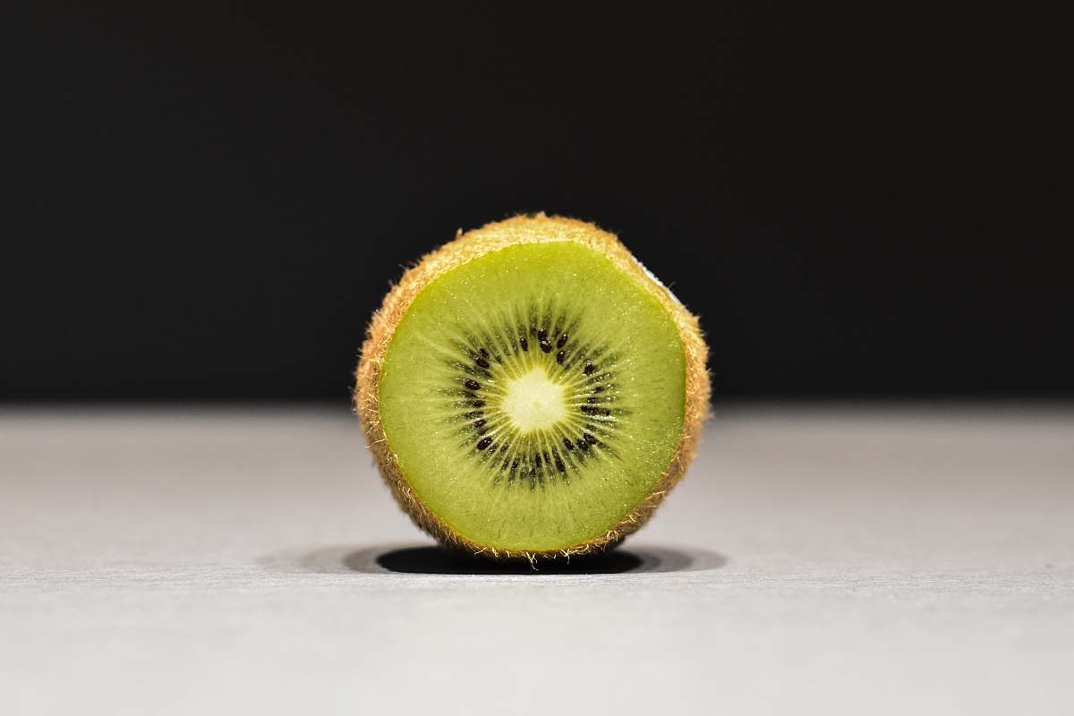 sports sliced kiwi on white surface ball