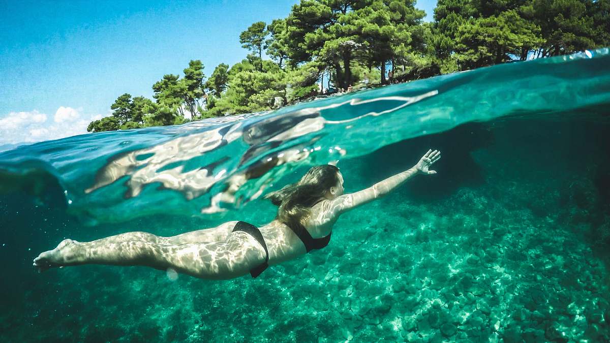 human woman in black bikini swimming underwater person