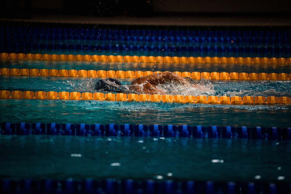 water man swimming in pool with lane ropes swimming