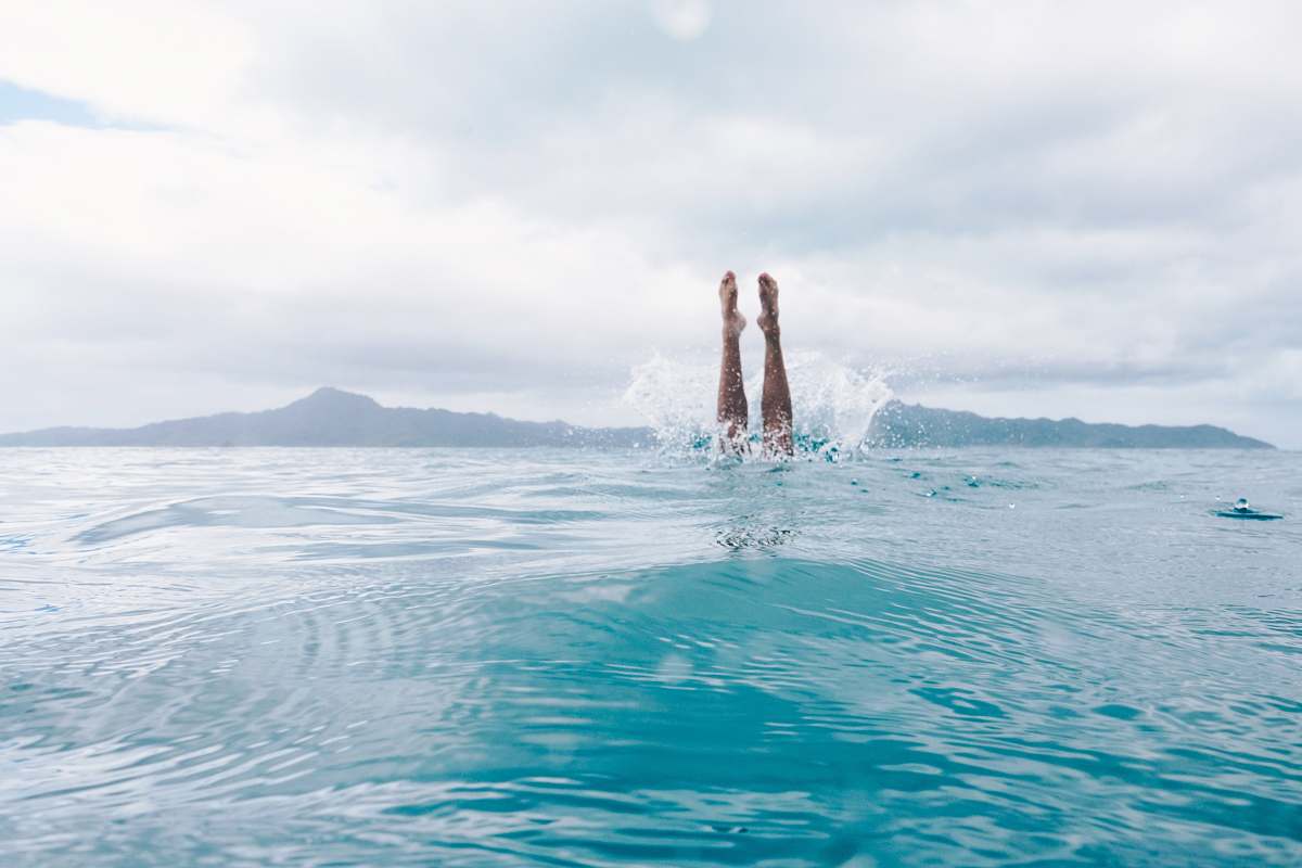 water person diving on body of water during daytime sport