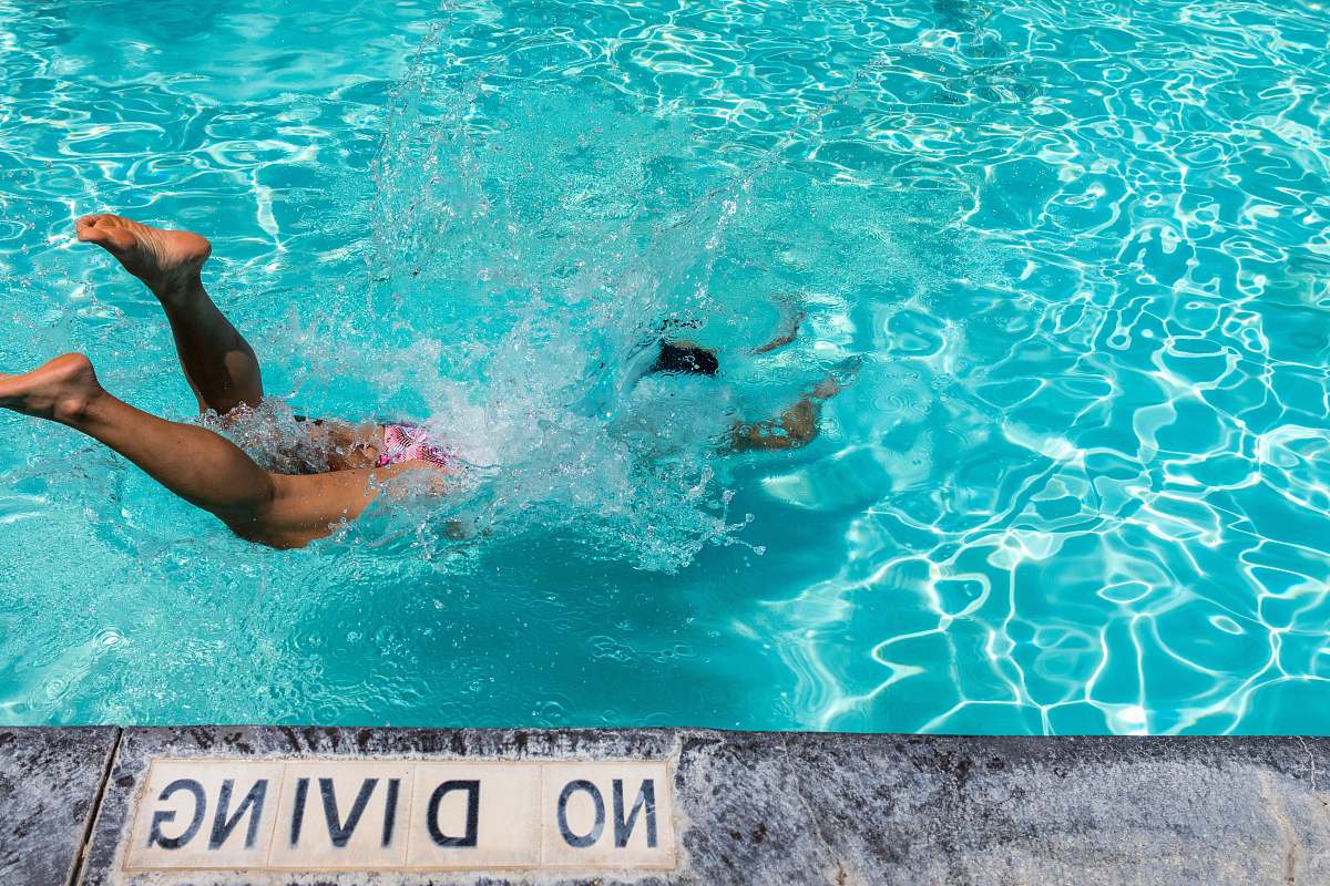swimming person diving on pool during daytime water