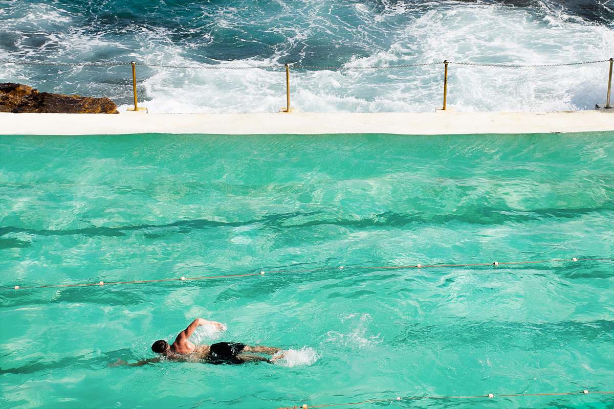 water person swimming on pool during daytime swimming