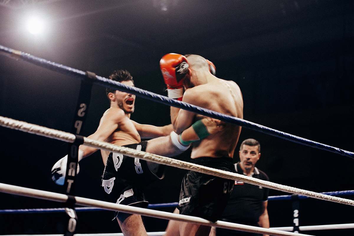 sport two person doing mix martial arts on white and blue stadium boxing