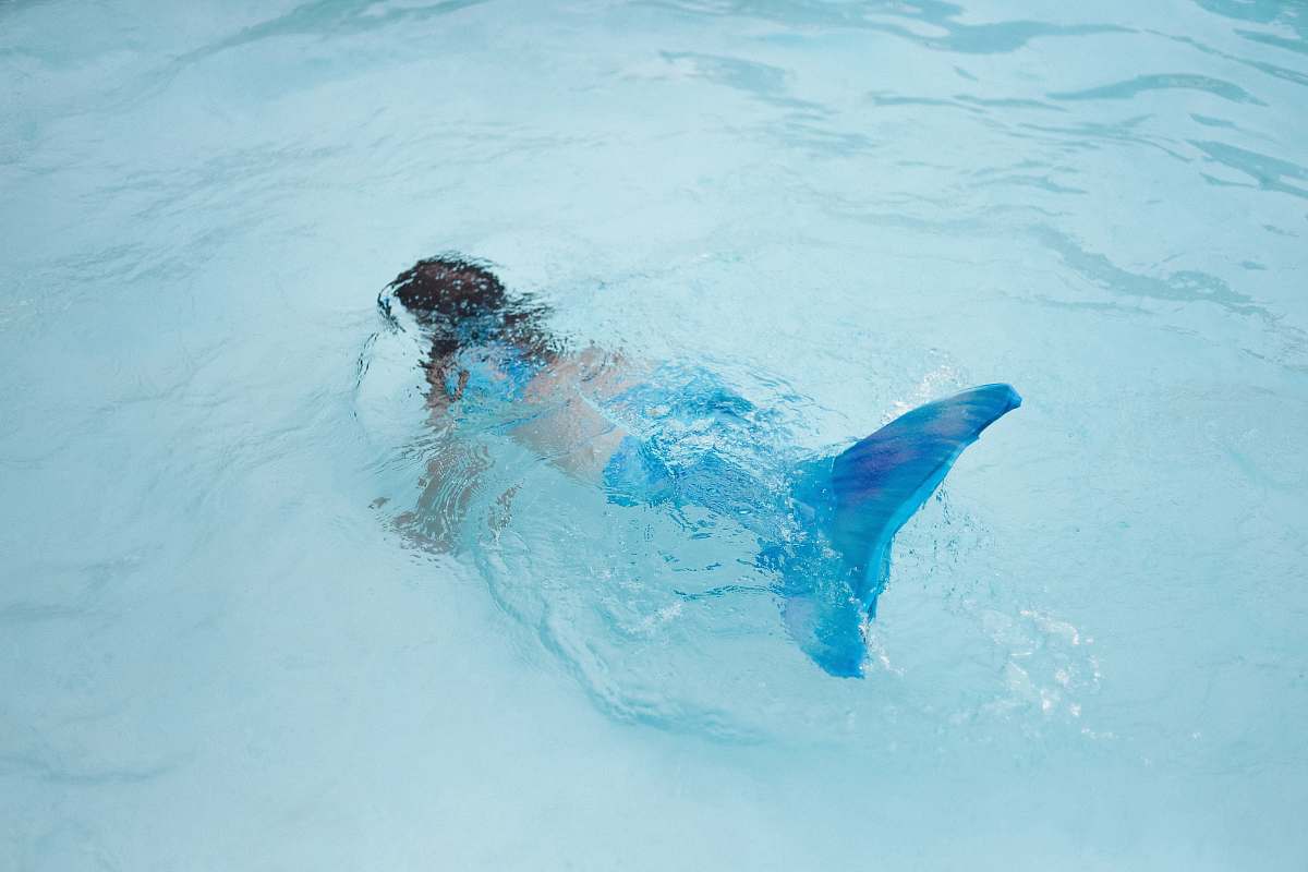 swimming girl with mermaid tail costume on pool human