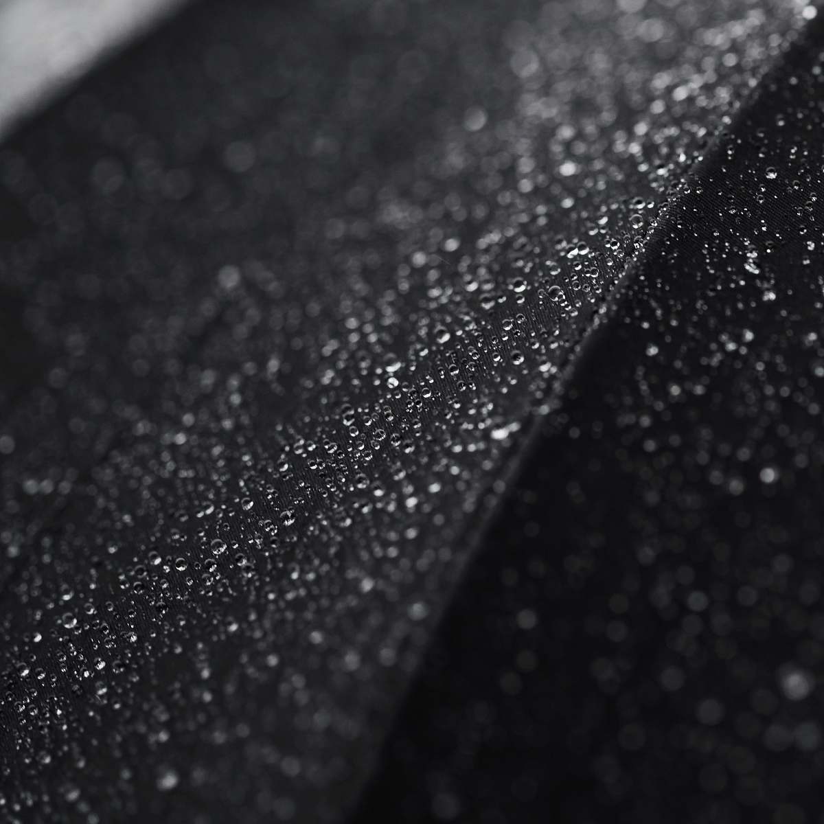 black-and-white Macro shot of tiny droplets of water on a black surface water drop