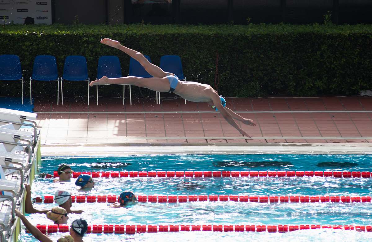 sports man dive on swimming pool during daytime diving