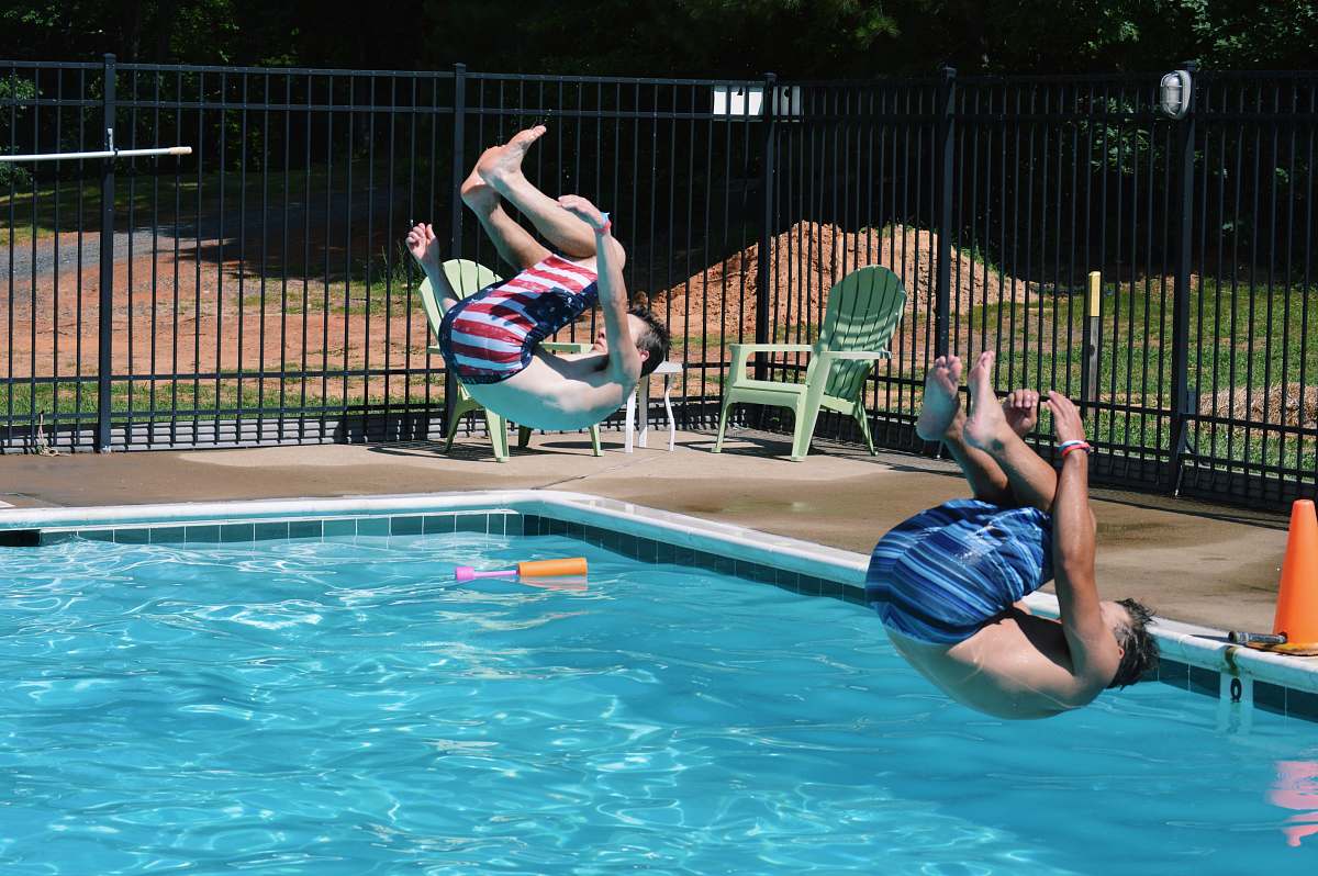 diving two men jumping on swimming pool diver