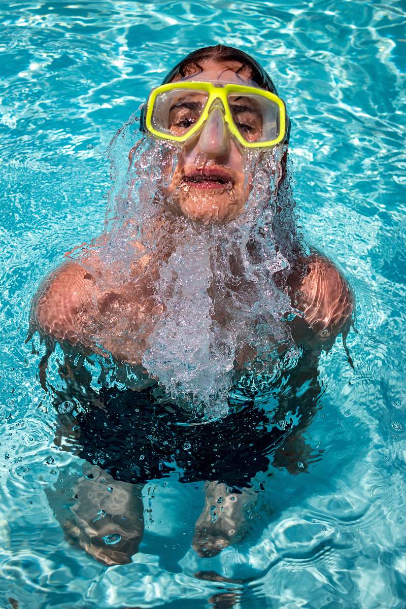swimming woman with goggles in the pool at daytime human