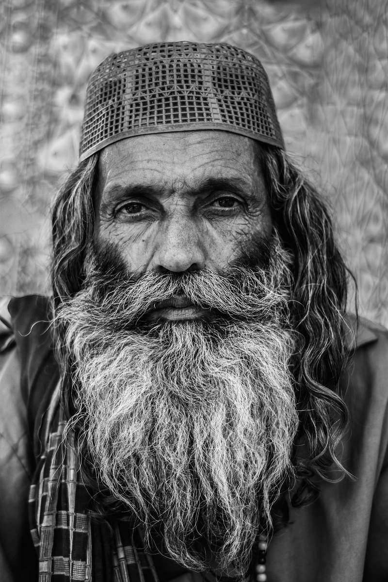 portrait grayscale photo of man in cap beard