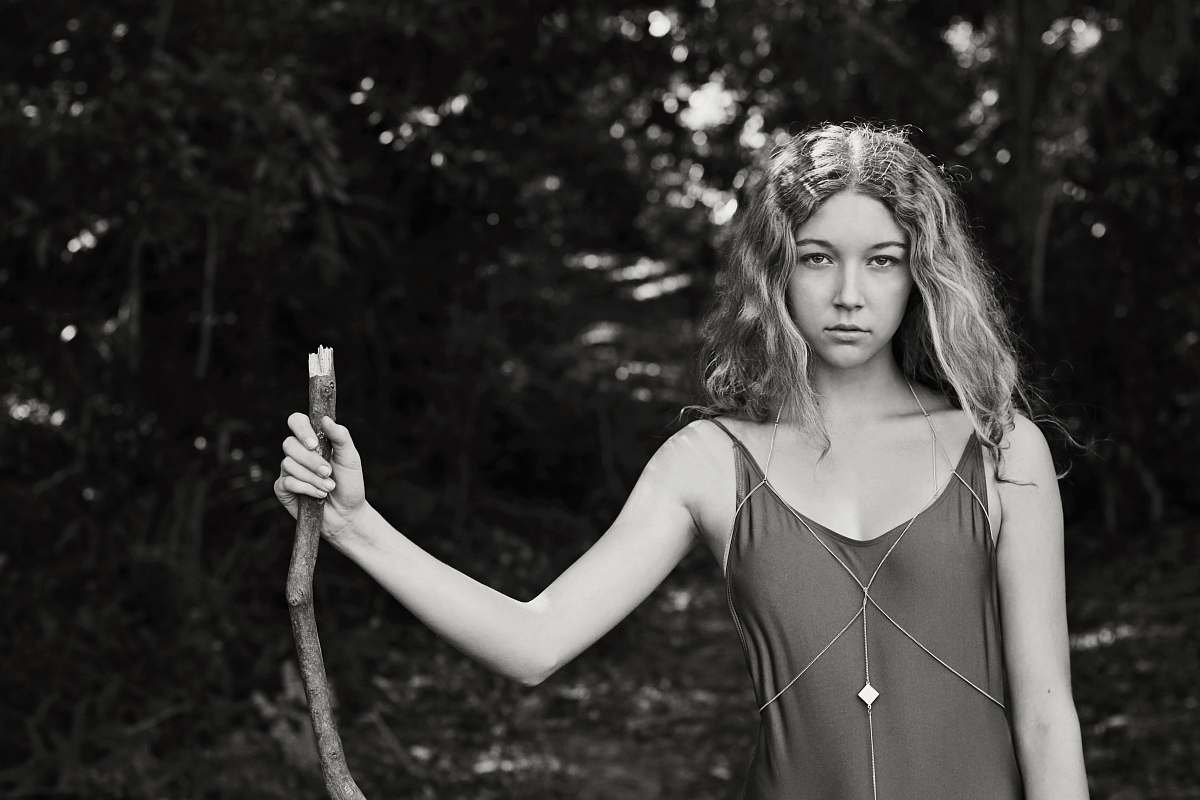 people grayscale photo of woman standing while holding stem female