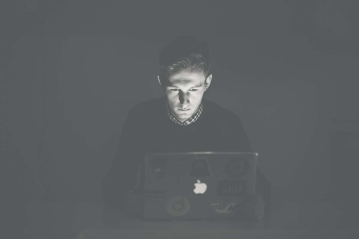 grey man staring at black MacBook face