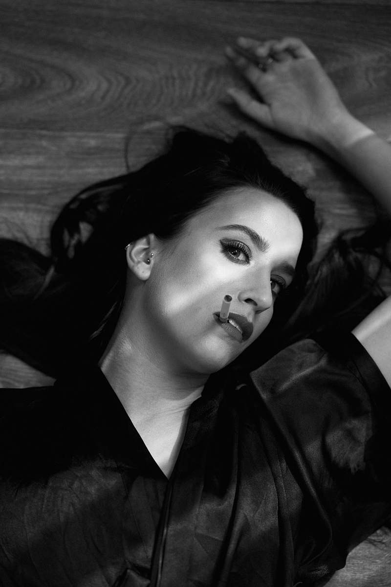 people grayscale photography of woman lying on wooden surface black-and-white