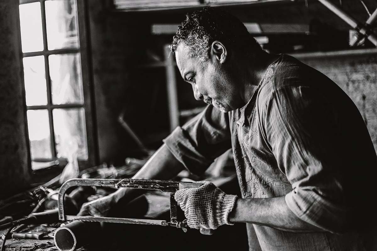 person man holding hack saw black-and-white