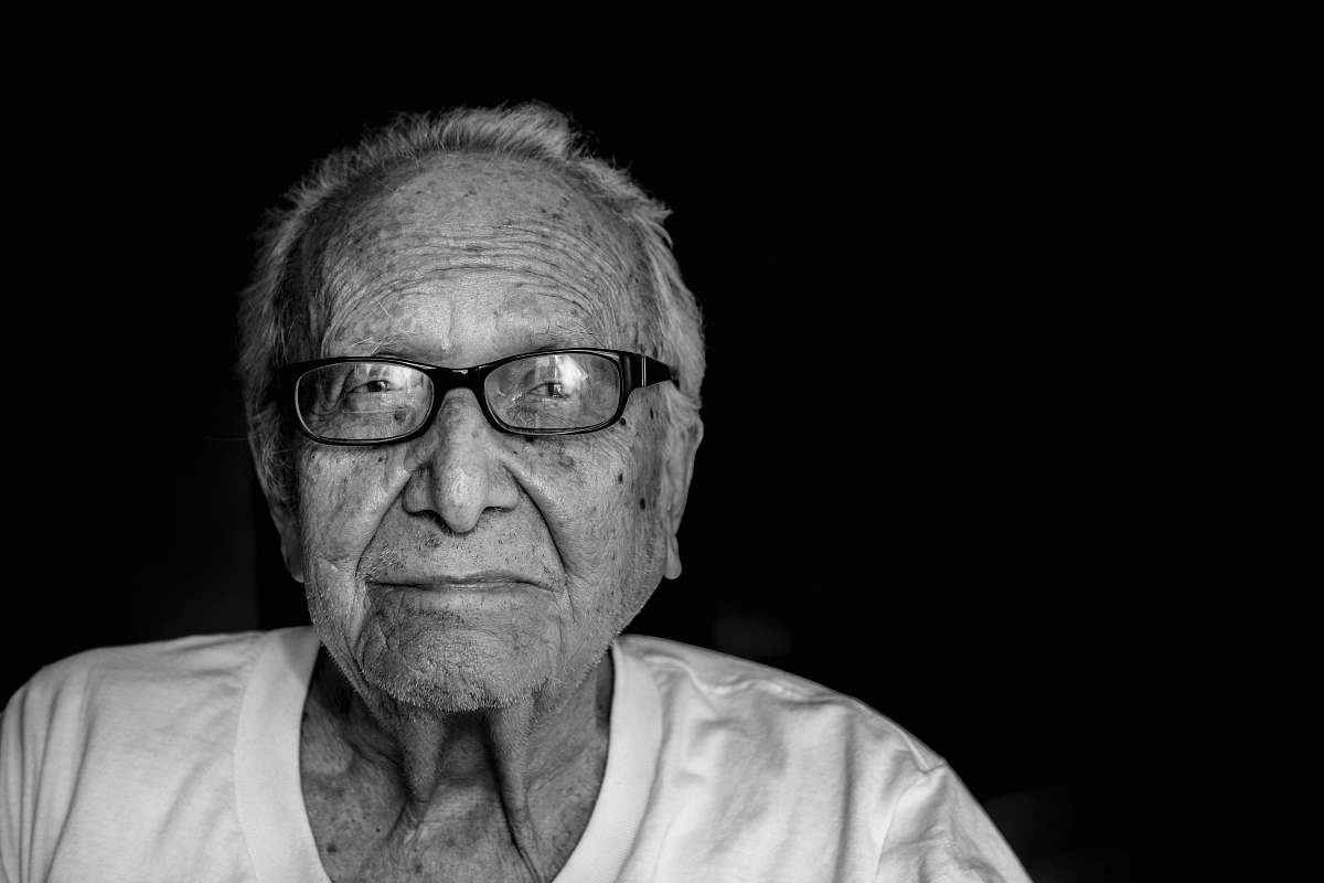 portrait grayscale photography of man wearing shirt and eyeglasses black-and-white