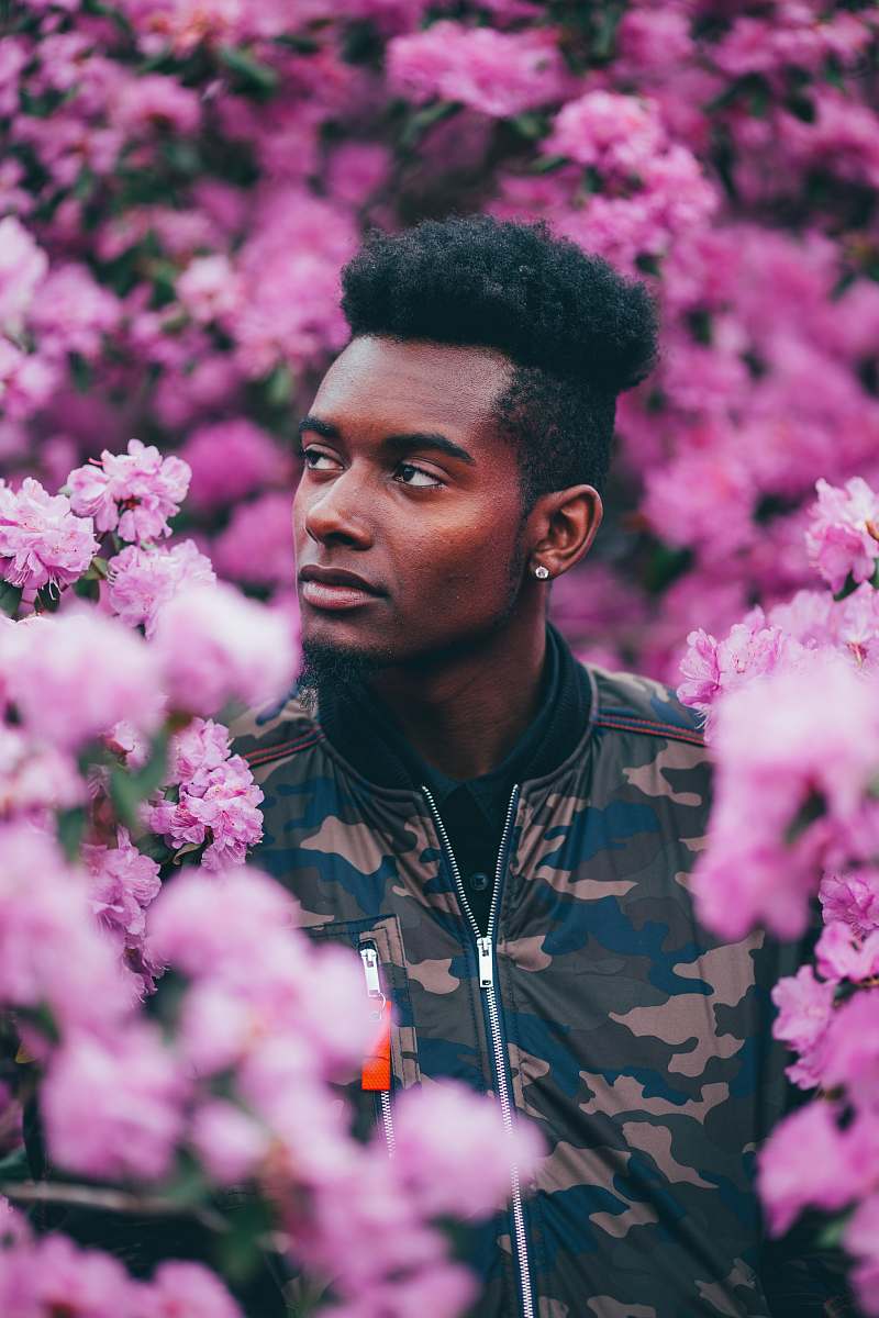 portrait man in camouflage jacket on garden looking up person