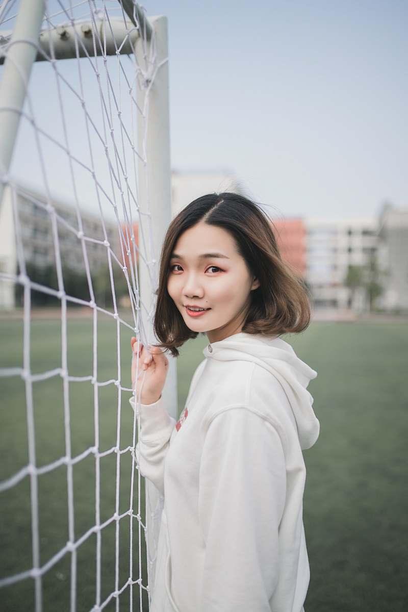 woman man in white pullover hoodie standing beside white goal net girl
