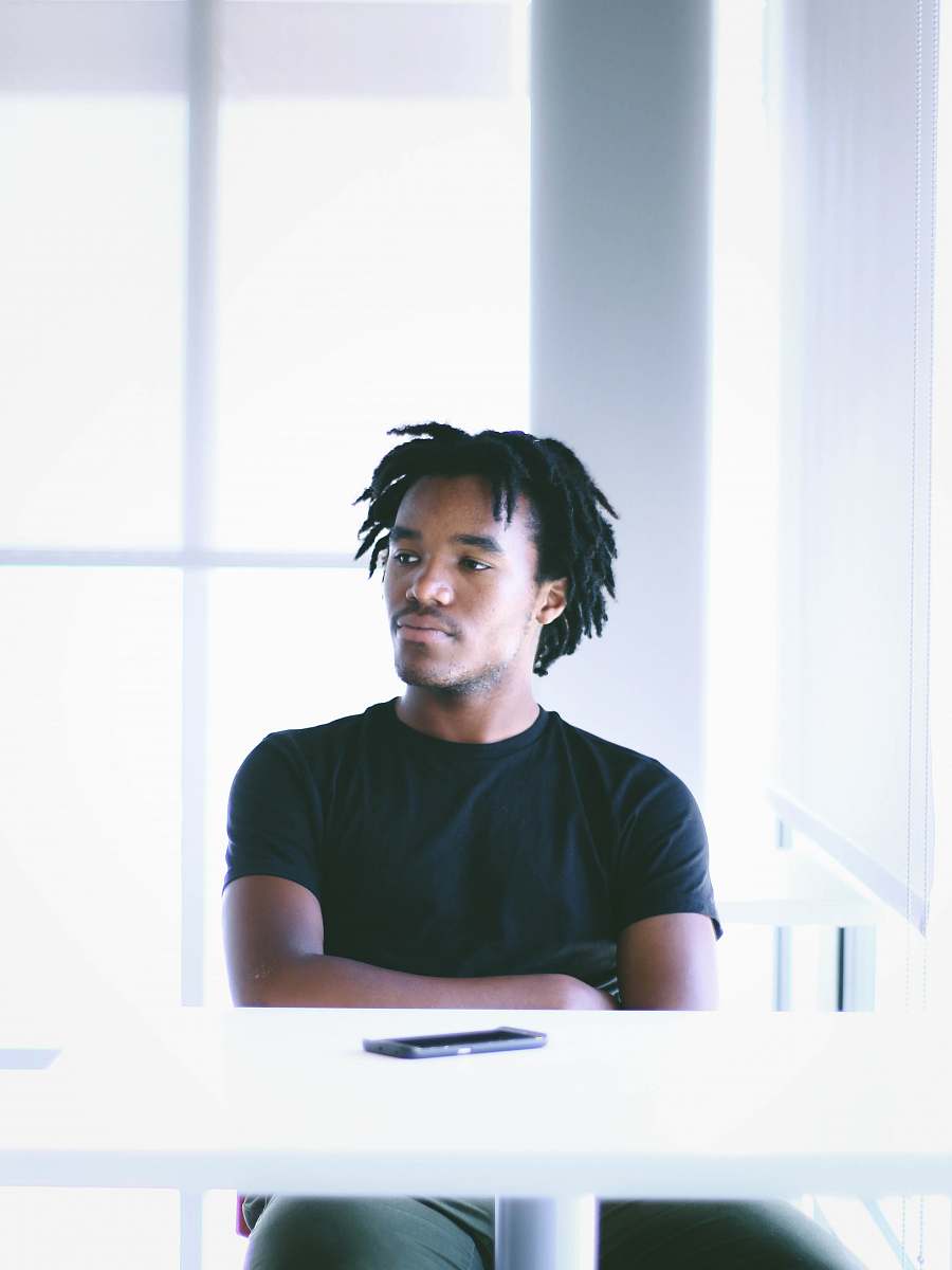 human man seating in front of white table person
