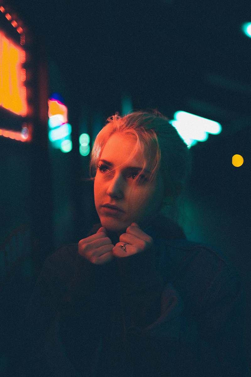 person selective focus photography of woman looking sideway while hands on chin human