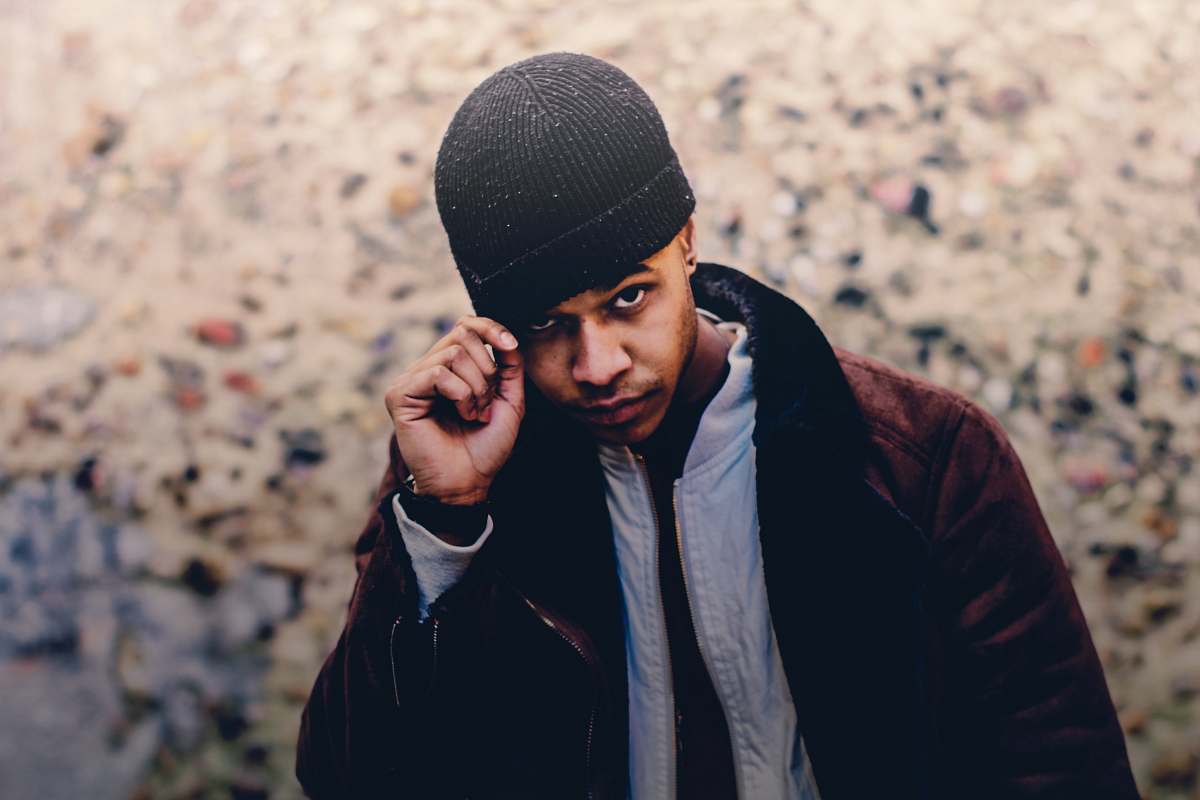 hat selective focus photo of man wearing brown coat and beanie beanie