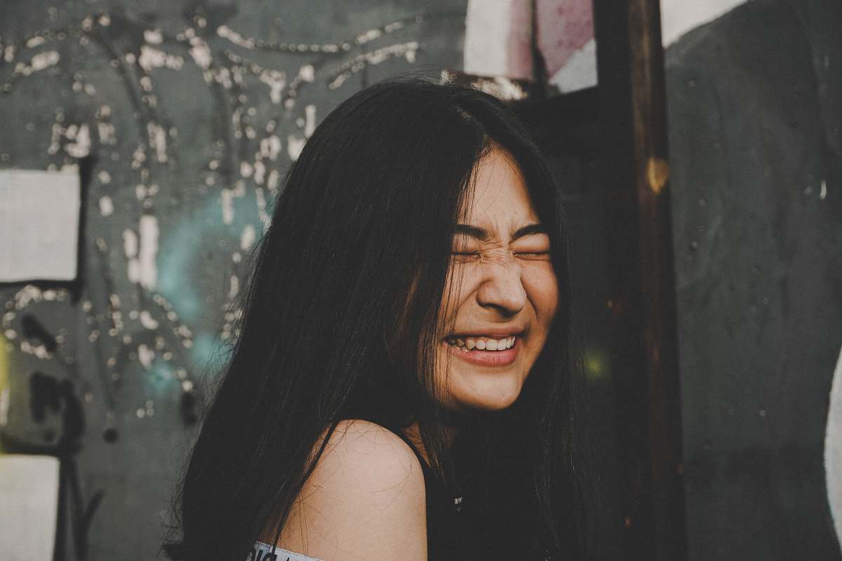 people smiling woman while closing her eyes photo human