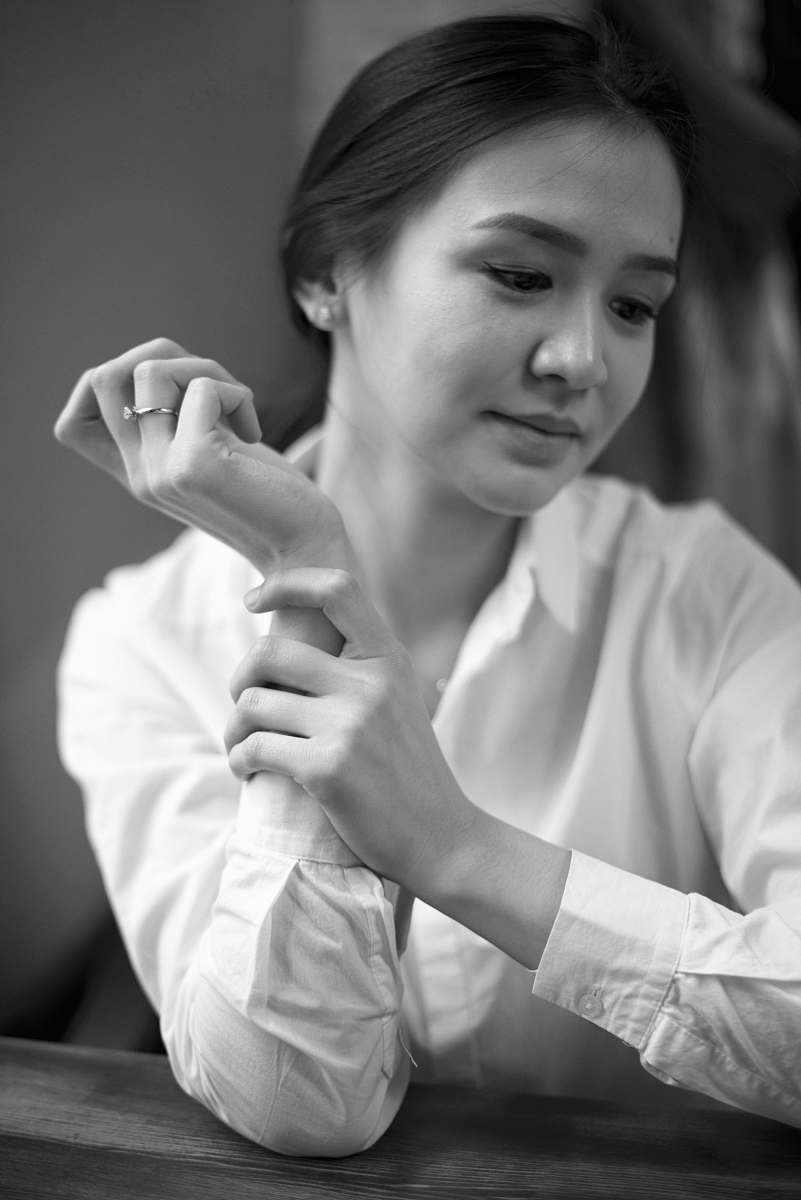 human woman holding her forearm black-and-white
