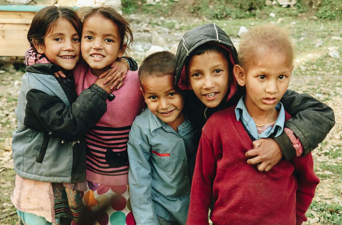 human group of children standing on grass field during daytime smile