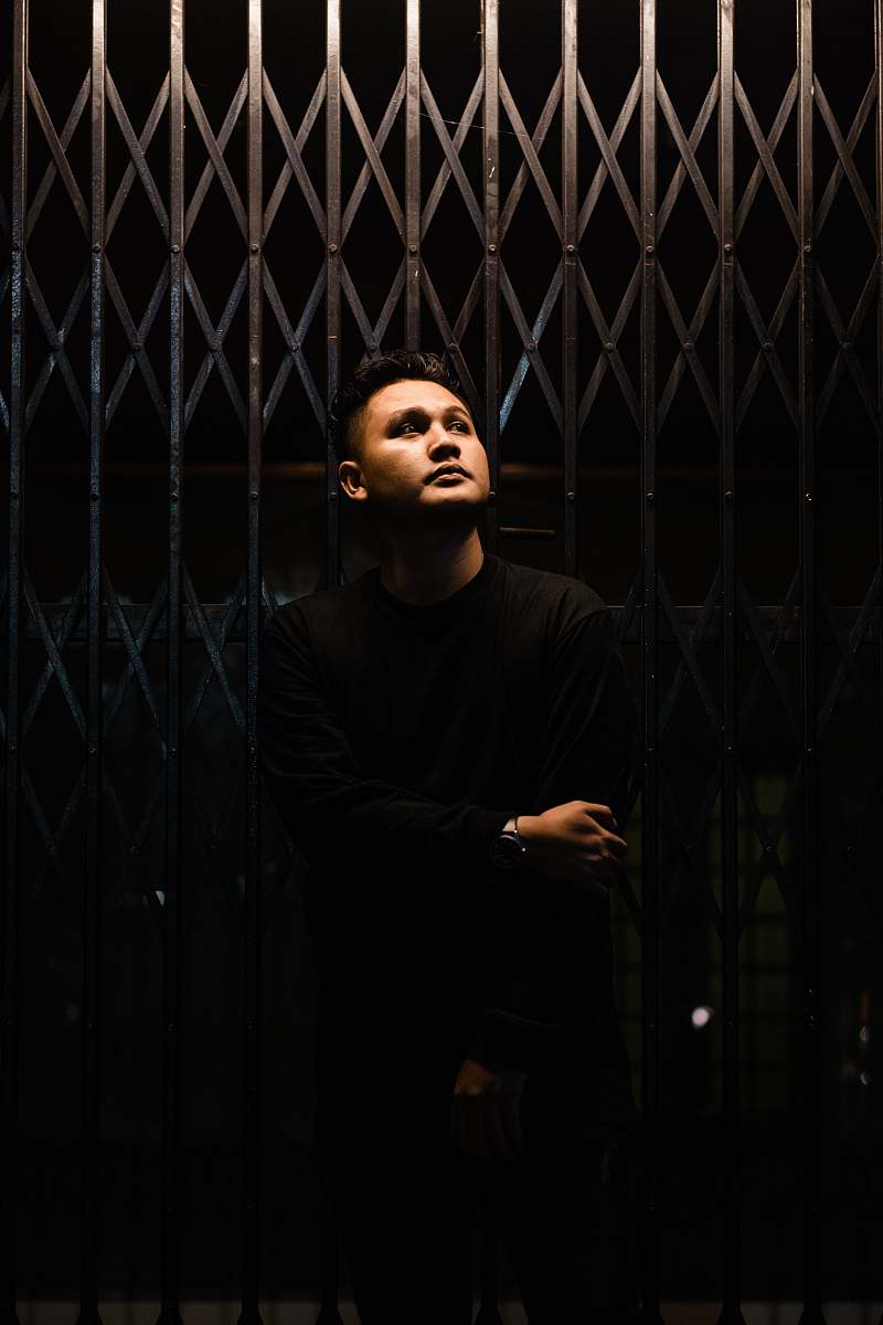 bandung minimalist photography of man standing in front metal gate indonesia