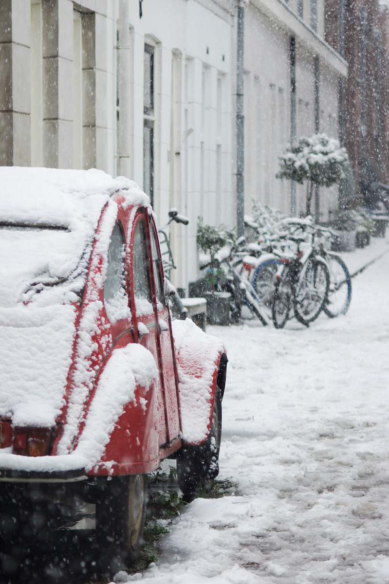 snow red Volkswagen beetle covered with snow blizzard