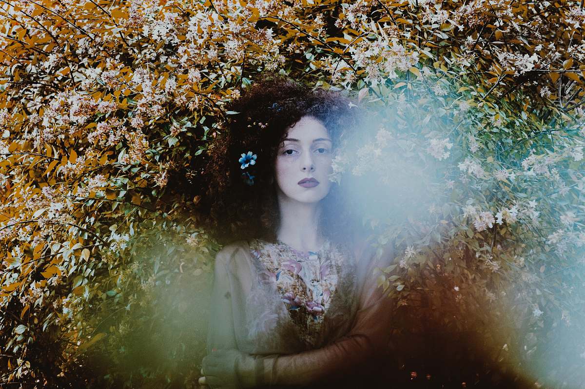 portrait woman standing under floral palnt female
